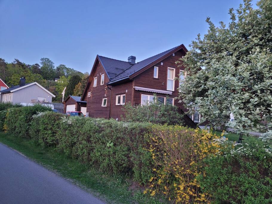 a brown house with a hedge in front of a house at Beautiful apartment near forest, sea and city in Sandefjord