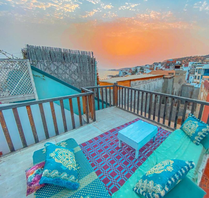 een balkon met een bank en een tafel bij Taghazout Surf House in Taghazout