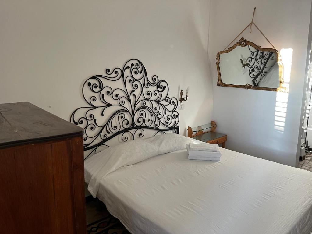 sypialnia z łóżkiem z czarno-białym zagłówkiem w obiekcie FraLePorte Vintage Apartment w mieście Palermo