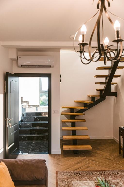a staircase in a living room with a chandelier at CAROLEA VILLAS in Ulcinj