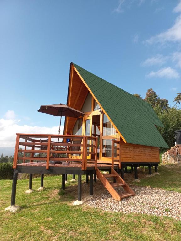 uma pequena casa com um telhado verde em exposição em Cabaña el Gran Cañon em Paipa