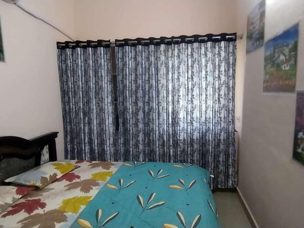 a bedroom with a bed in front of a window at P. G. REDDY HOME STAY in Tirupati