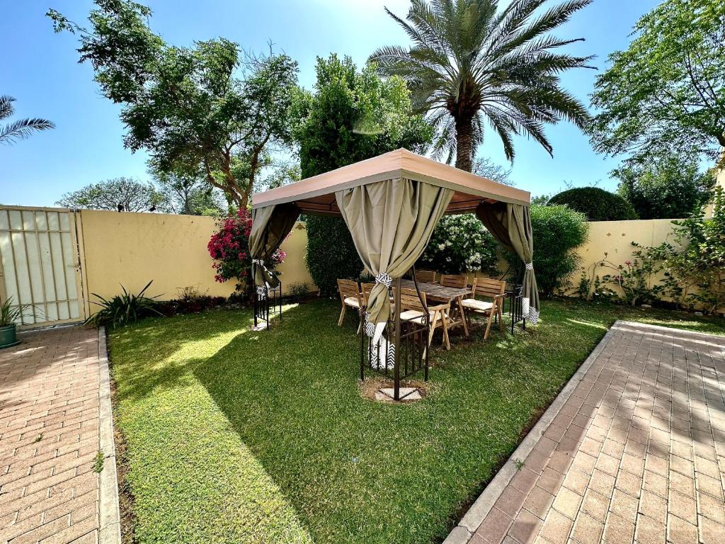 Lux BnB Springs Villa Private Garden في دبي: شرفة مع طاولة وكراسي في الفناء