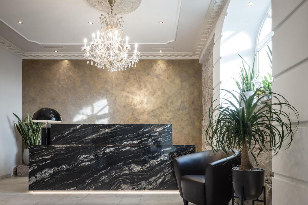 a lobby with a black marble counter and a chandelier at Hotel Donauhof in Deggendorf