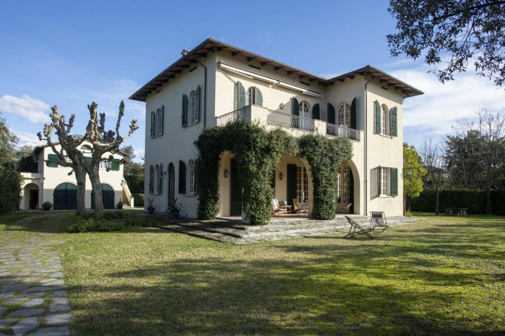 a large white house with ivy on it at Villa Eden - Homelike Villas in Forte dei Marmi