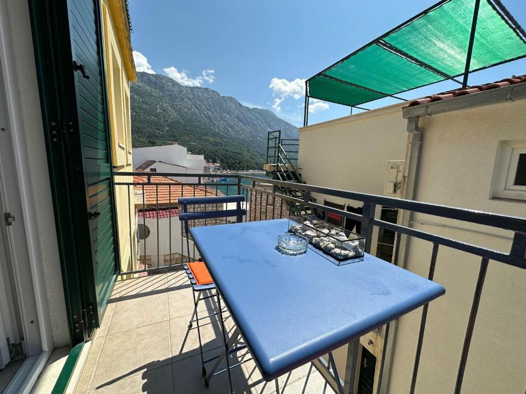 una mesa azul en un balcón con vistas en Apartment SEAGULL, en Igrane