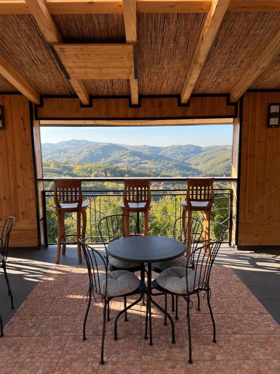 a table and chairs on a porch with a view at Zdravkovac Country Club - Hotel in Topola
