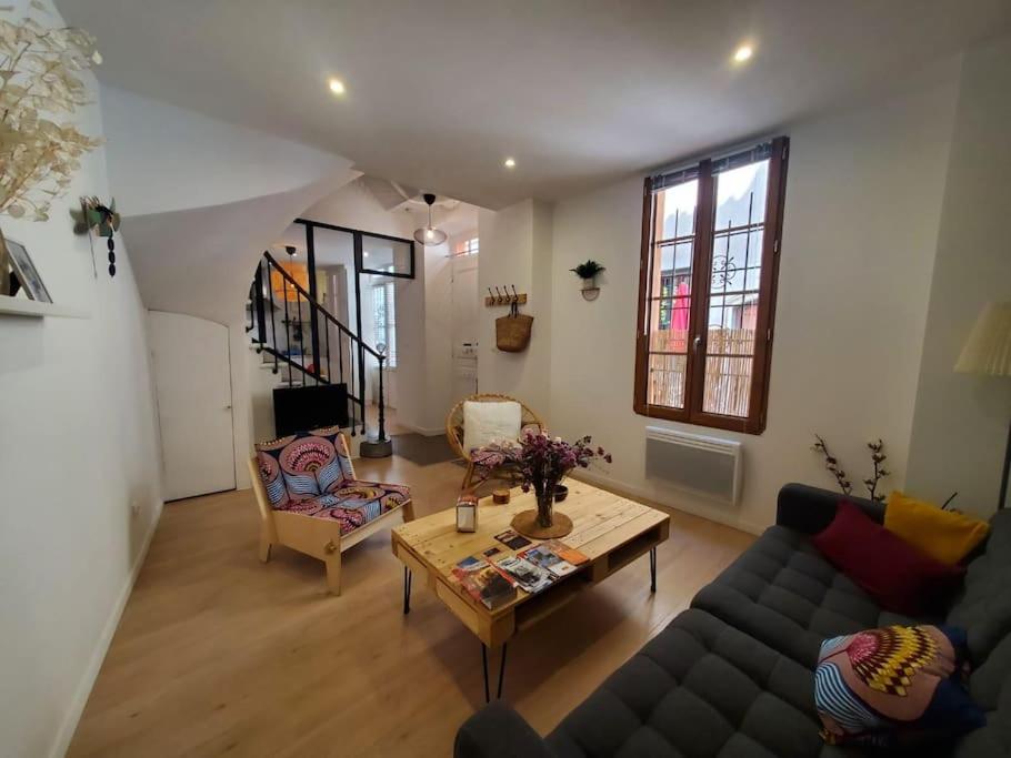 sala de estar con sofá y mesa en La Louve - maison de ville en Narbonne