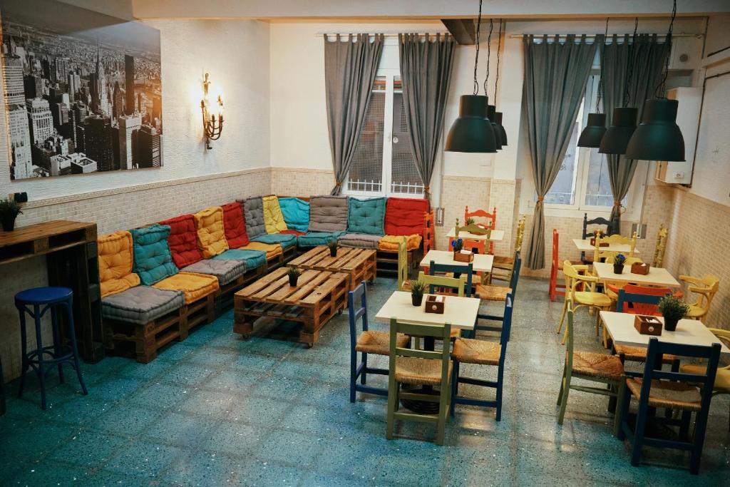 un restaurante con sofá, mesas y sillas en LOFT HOSTAL Group, en Lloret de Mar