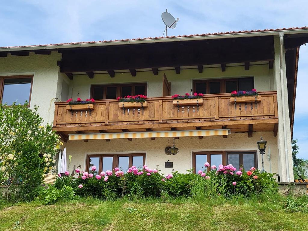 卑爾根的住宿－Ferienwohnungen Rodler，一座房子,阳台上种着鲜花