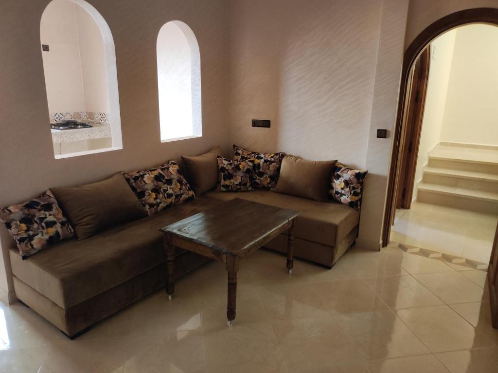 a living room with a couch and a table at Appartements et chambres meublés in Mirleft