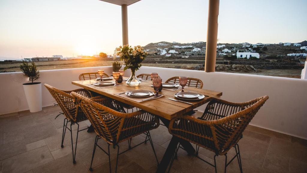 einen Esstisch und Stühle mit Meerblick in der Unterkunft Gaia Mykonos Villas & Suites in Tagou