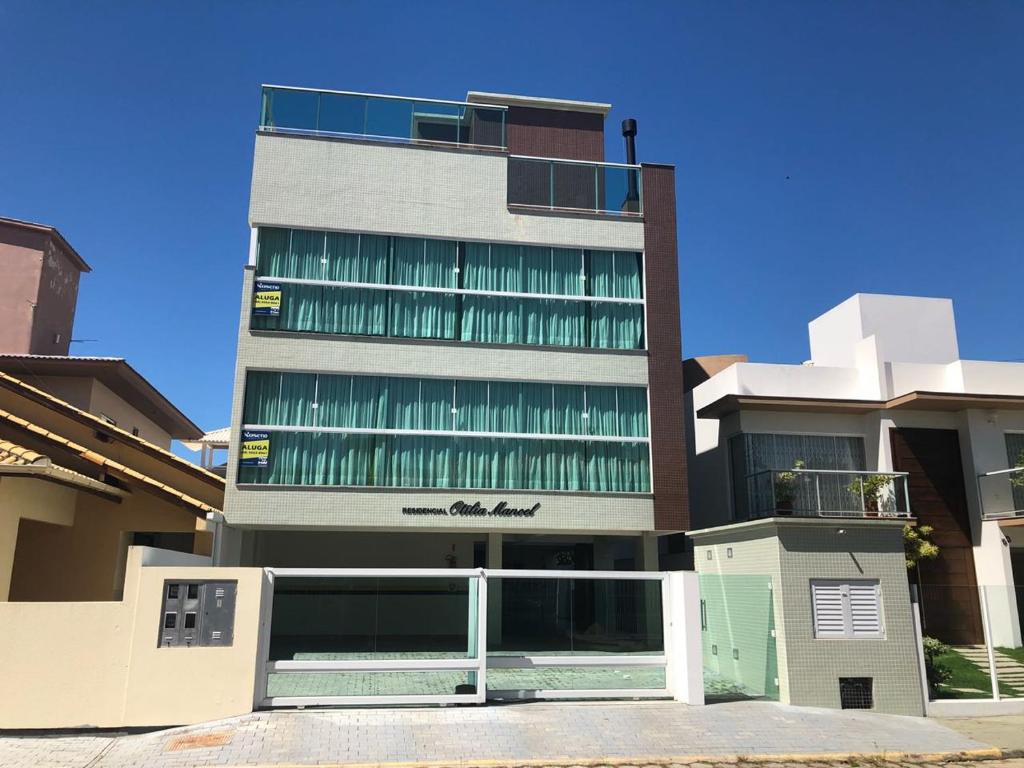 un grand bâtiment avec des fenêtres vertes sur son côté dans l'établissement Apartamento a 150 metros do mar, à Governador Celso Ramos