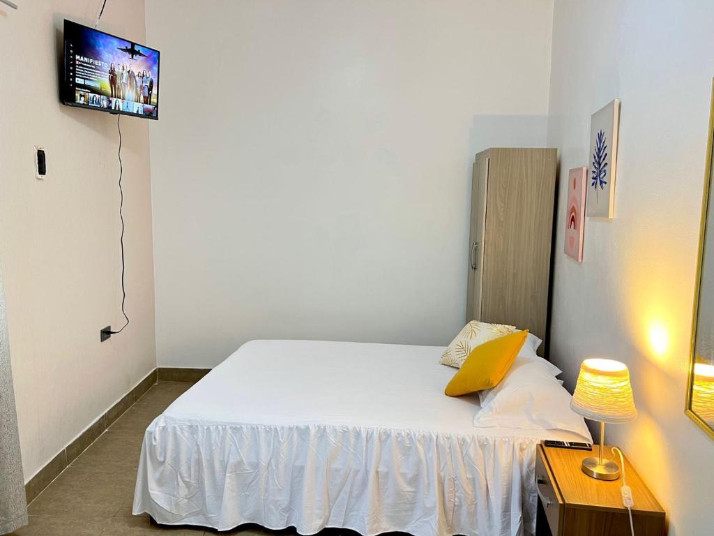 a small bedroom with a bed and a tv at Margarita's room in Morales