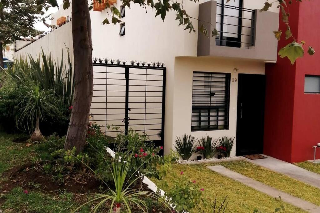 una casa roja y blanca con una puerta negra en Casa como nueva, cómoda y tranquila, en Guadalajara