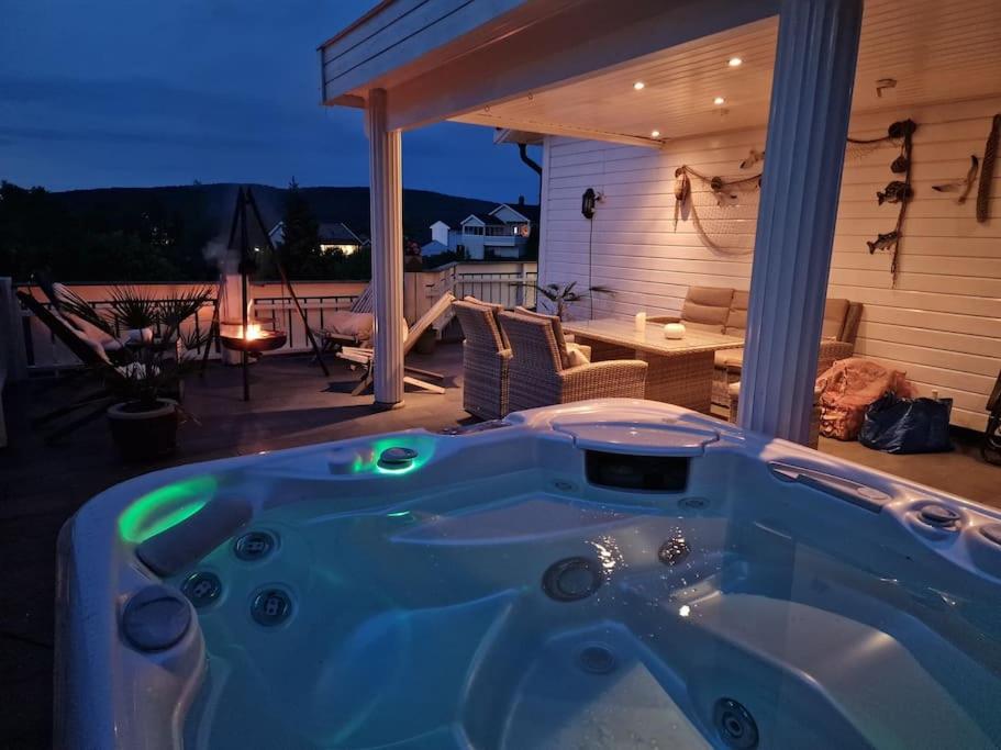 eine Whirlpool-Badewanne auf einer Terrasse mit einem Tisch in der Unterkunft Sætre, Asker, egen båt ,kajakk,jacuzzi, rolig sted in Asker