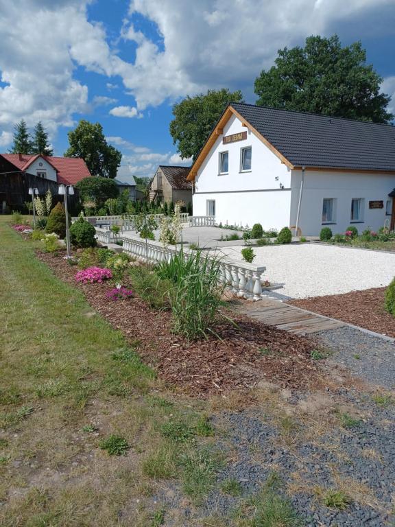 a garden in front of a white house at Agroturystyka Pod Dębami in Bolesławiec