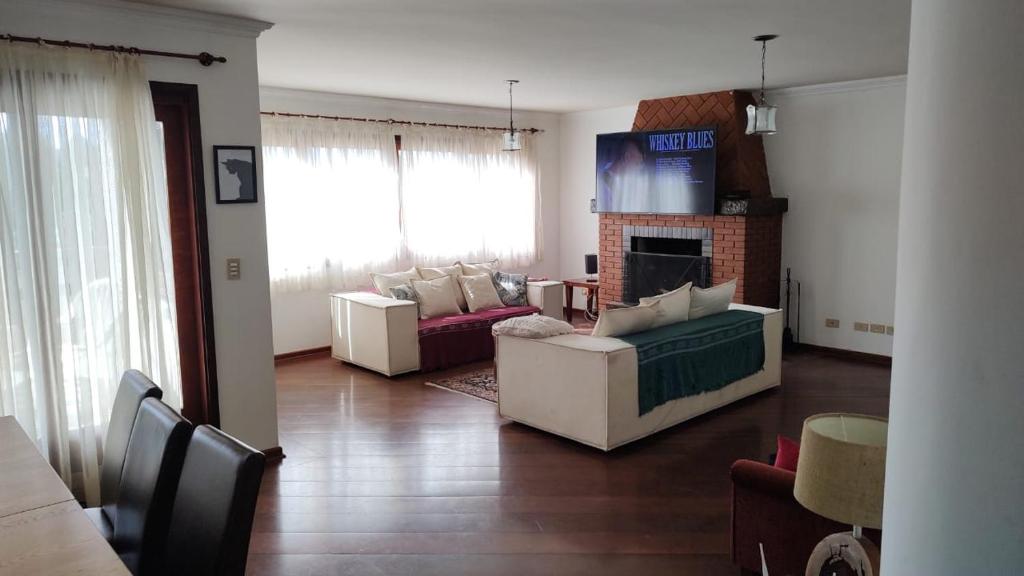 ein Wohnzimmer mit 2 Sofas und einem Kamin in der Unterkunft Apartamento no Morro do Elefante (Capivari) in Campos do Jordão
