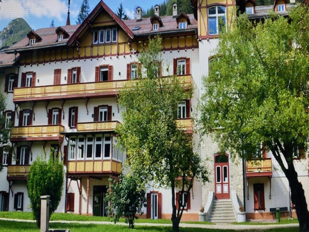 un grand bâtiment avec des arbres devant lui dans l'établissement Un soffio d’aria sulle Dolomiti, à Chiapuzza