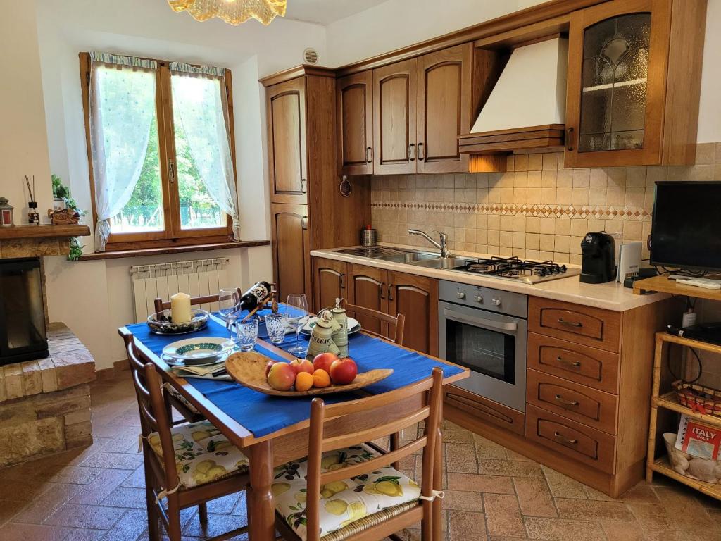 una cocina con una mesa con un bol de fruta. en Villa Il Fontanino, en Monticiano