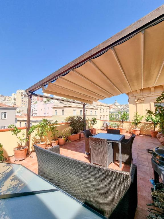 a patio with a table and chairs under an umbrella at Upper Garden Guest House in Cagliari