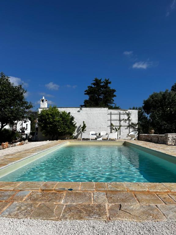a swimming pool in front of a house with a lighthouse at trullo Giardino Sotto La Luna in Ceglie Messapica