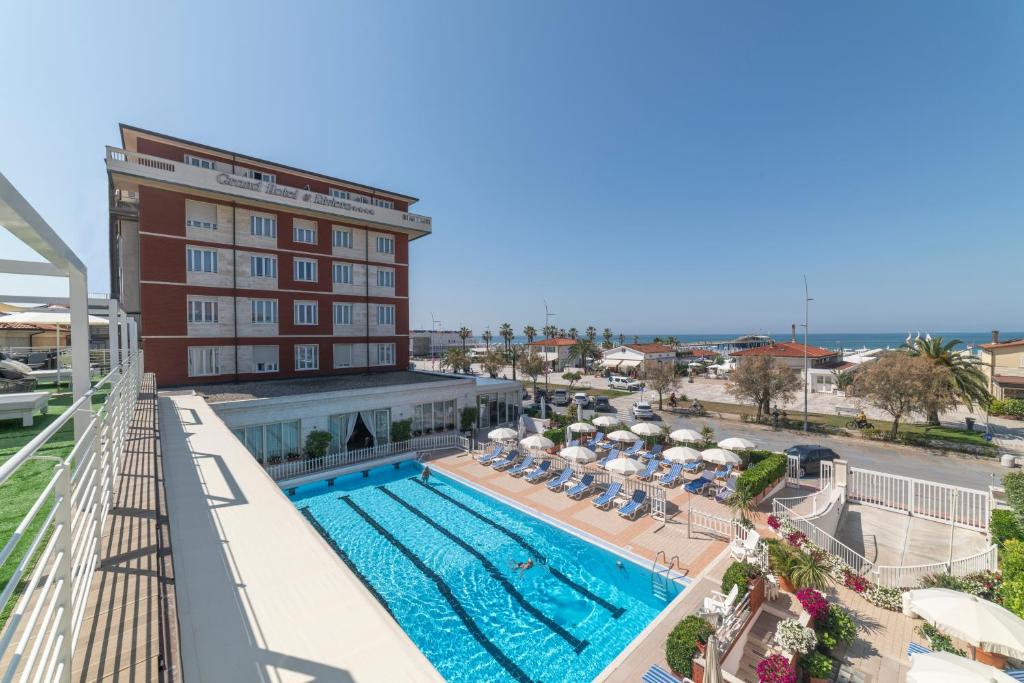 een uitzicht over een zwembad met een hotel bij Grand Hotel & Riviera in Lido di Camaiore