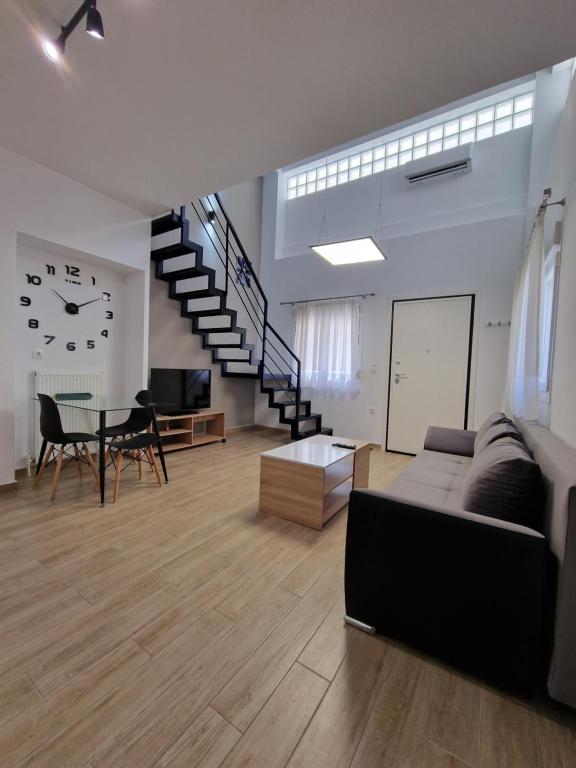 un soggiorno con divano, tavolo e orologio. di SKG City Loft a Salonicco