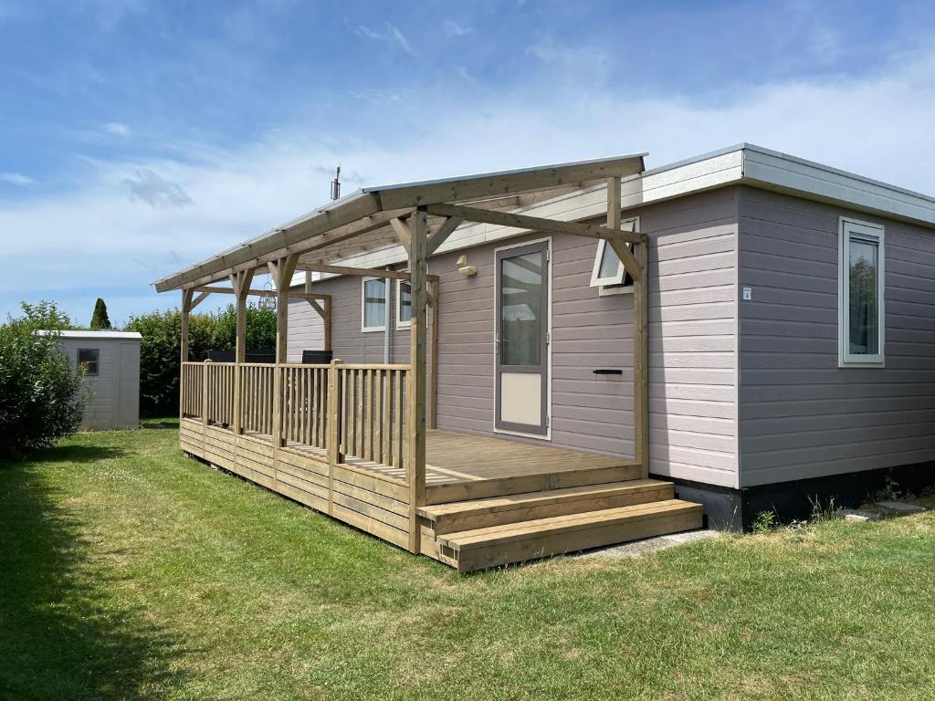 a small house with a porch and a deck at Chalet Boerennest bij strand en duinen - Midicamping Van der Burgh - Rockanje in Rockanje