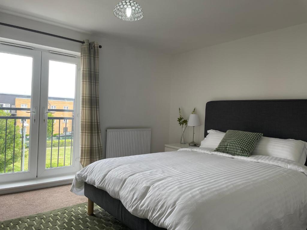 a white bedroom with a large bed and a window at Luxury Large Beds in West Thurrock 3 bathrooms 1 en suite Netflix Free Parking in Grays Thurrock