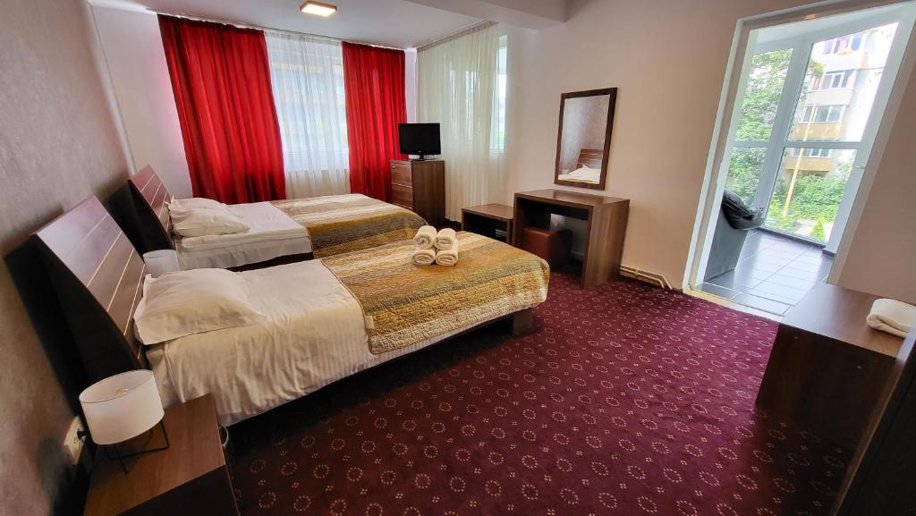 een hotelkamer met twee bedden en een raam bij Boutique Global in Braşov