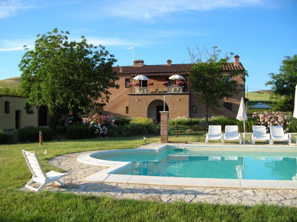 une maison avec une piscine en face d'une maison dans l'établissement Agriturismo Il Poderino, à Asciano