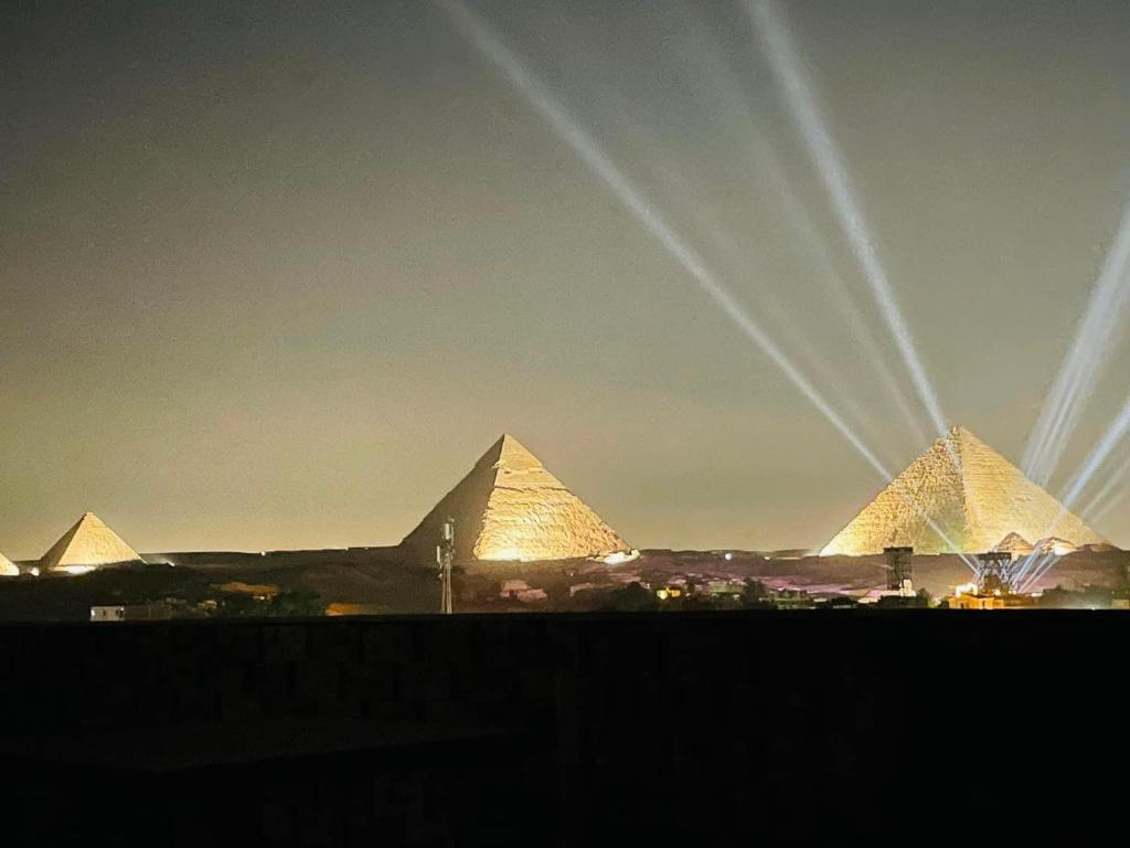 a view of the pyramids of giza at night at Zein Pyramids View - Guest House in Cairo