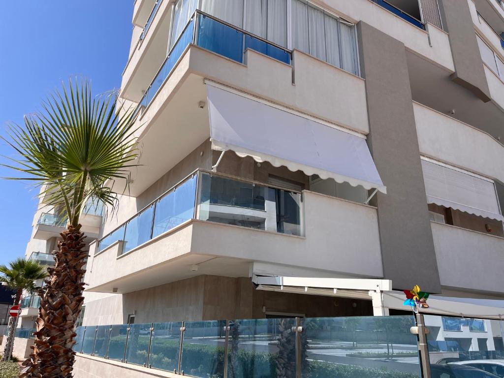 a building with a palm tree in front of it at Casa Giorgia Monopoli in Monopoli