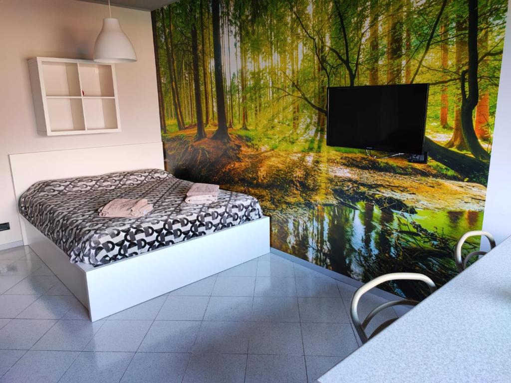 una camera da letto con un murale raffigurante una foresta di Claudia Lake View appartamento a Gavazzo Nuova