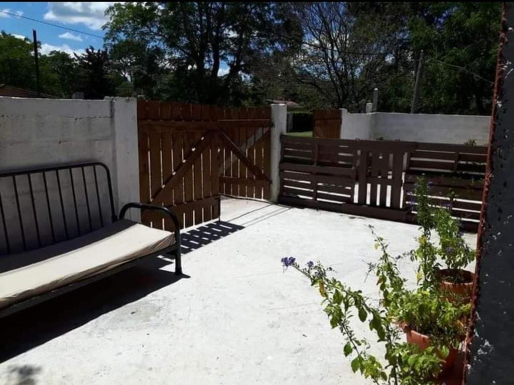 een patio met een bank en een houten hek bij Las Madres Selvas in Las Toscas