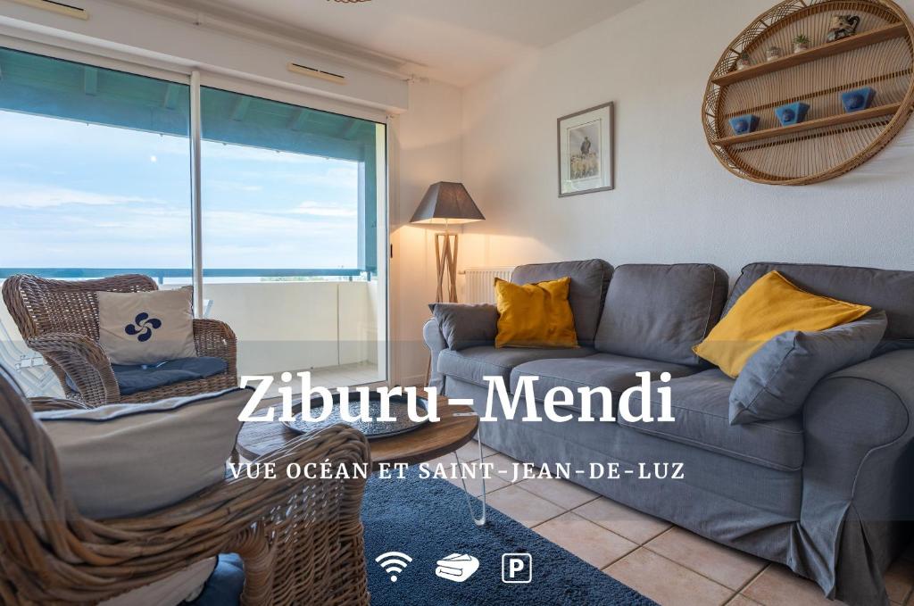sala de estar con sofá y ventana en Ziburu Mendi - Appartement Calme, Vue Mer, Parking - WiFi, en Ciboure