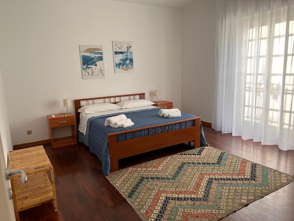 een slaapkamer met een bed en een tapijt op de vloer bij Casavacanze nel blu Maestrale in Isola delle Femmine