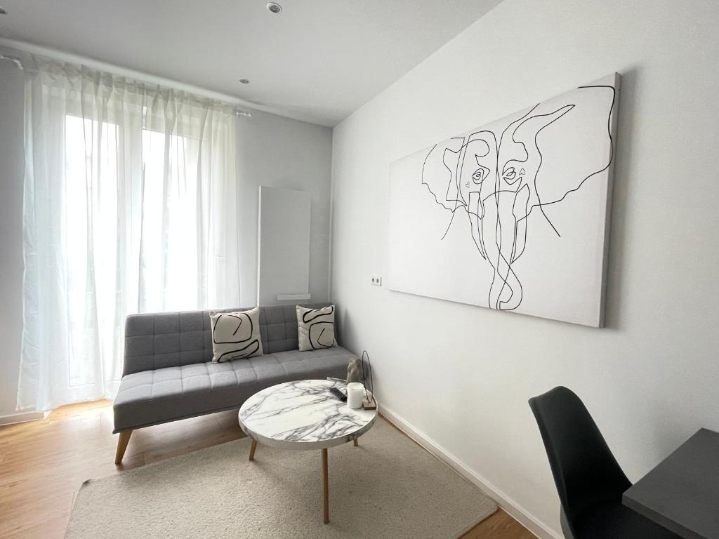 ein Wohnzimmer mit einem Sofa und einem Tisch in der Unterkunft 70qm - 3 rooms - free parking - city - MalliBase Apartments in Hannover