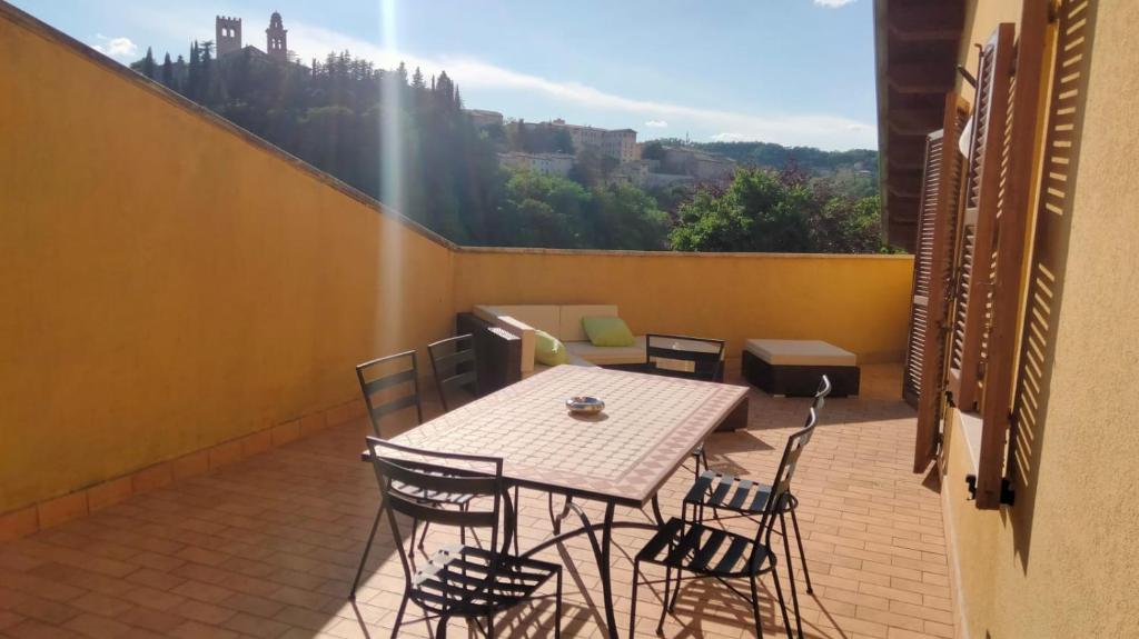 eine Terrasse mit einem Tisch und Stühlen auf dem Balkon in der Unterkunft I Tre Lecci in Nocera Umbra