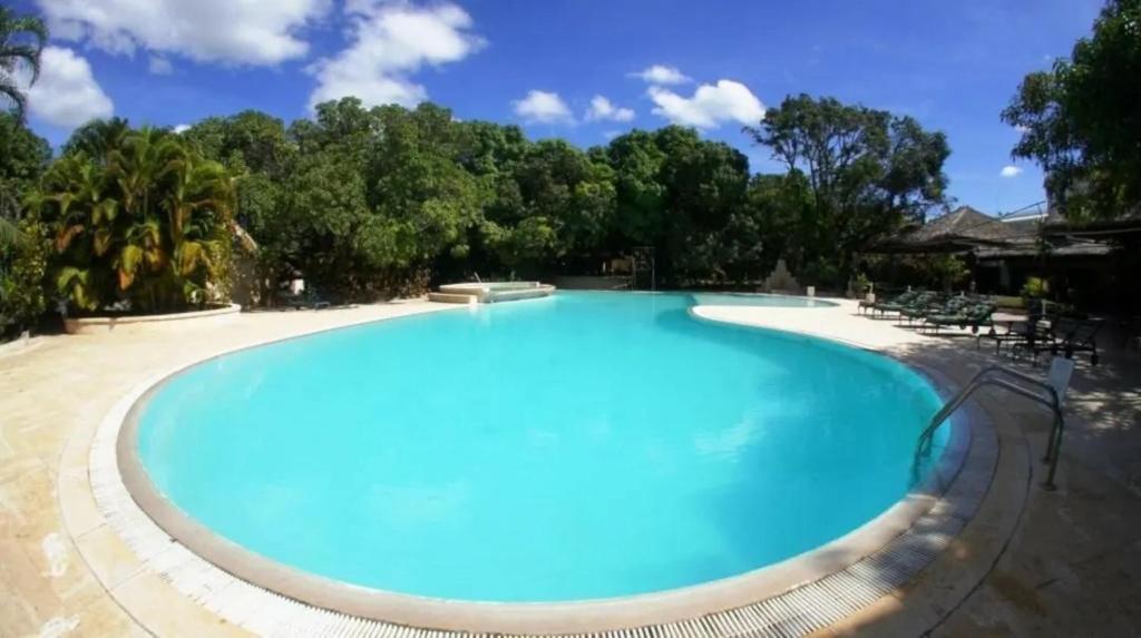a large blue swimming pool with trees in the background at SUNNY HOTEL MAHAJANGA in Mahajanga