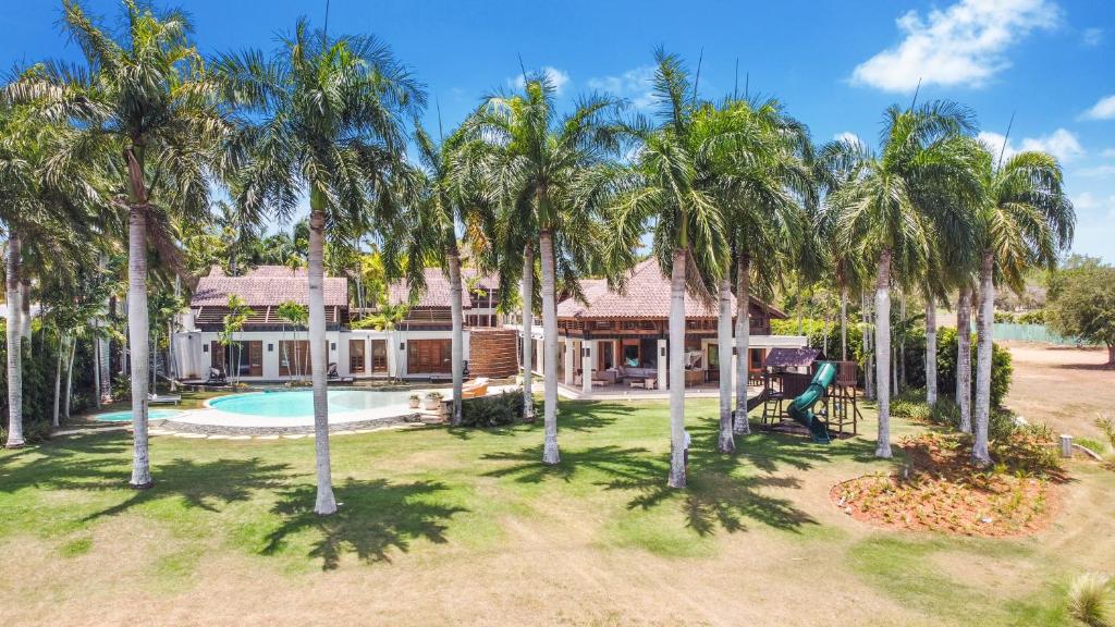 an aerial view of a house with palm trees at Luxurious 8-BR Villa with Ocean View, Jacuzzi, Home Cinema and Resort Access in Casa de Campo in La Romana