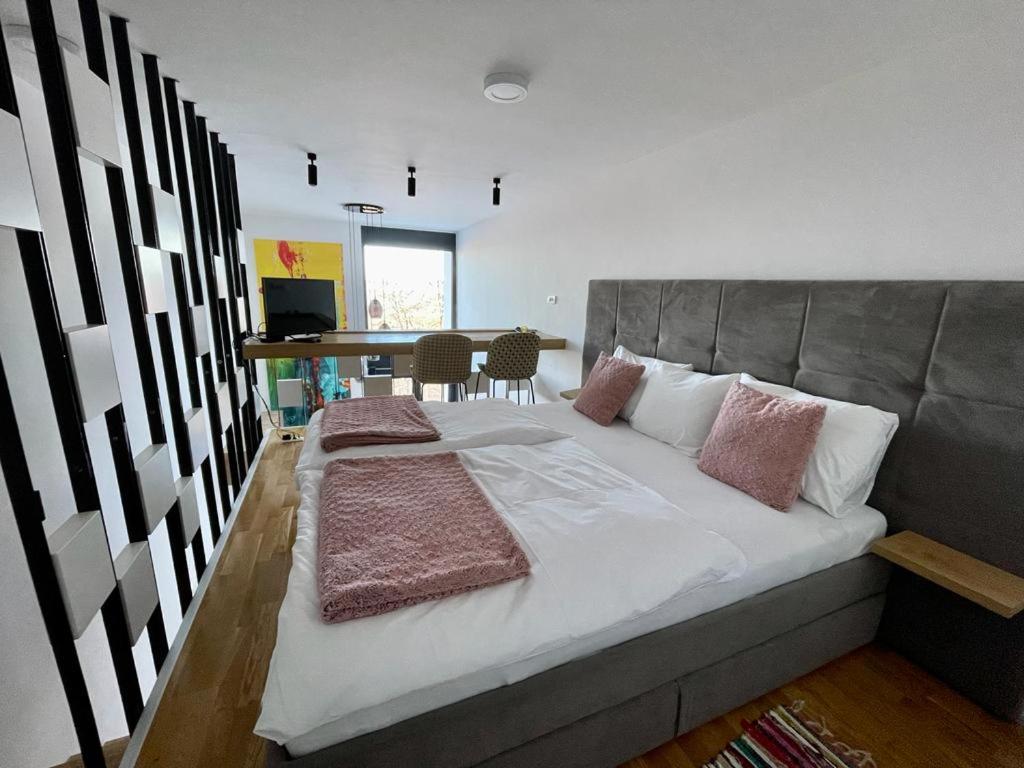 a bedroom with a large bed with pillows on it at Bjelasnica Tuzlaks Apartment -SAUNA-free parking in Bjelašnica