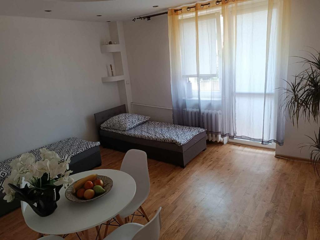 a living room with a table and a couch at Apartament fabryczny Comfort in Pisz