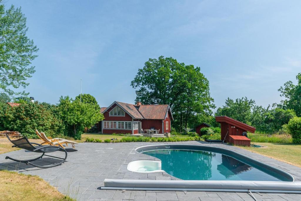 une arrière-cour avec une piscine et une maison dans l'établissement Idyllic house in Molnbo with heated pool near Gnesta, à Mölnbo