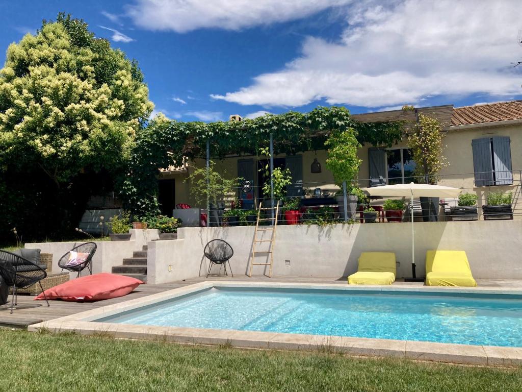 a swimming pool with colorful cushions next to a house at Villa avec piscine à Fuveau in Fuveau