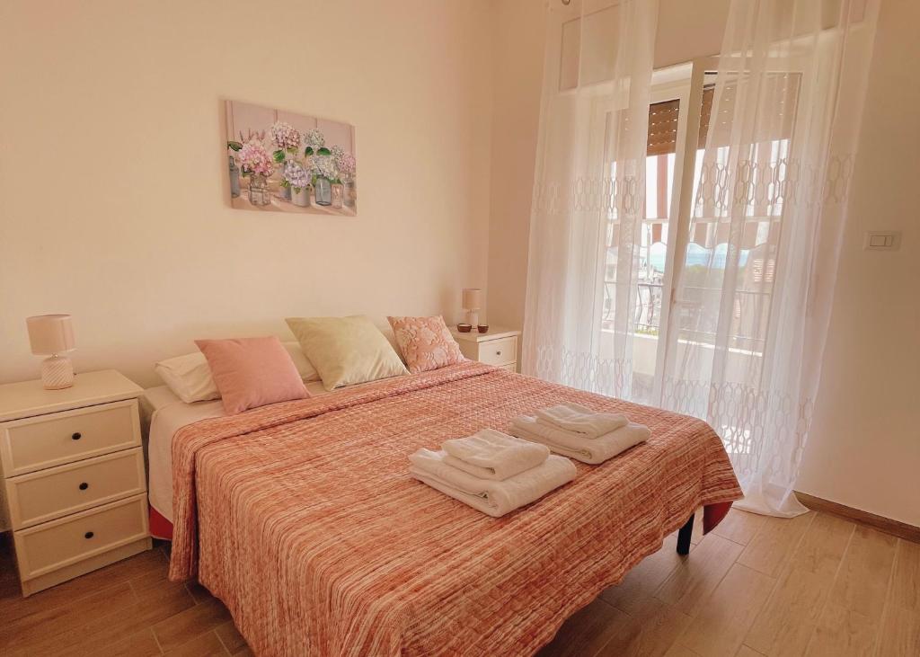 een slaapkamer met een bed met twee handdoeken erop bij Appartamento Corallo Rosso e Stella Blu in Belvedere Marittimo