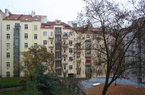 プラハにあるBright & Cosy Room with Own Shower and Kitchenetteの目の前に木々が植えられた白い大きな建物