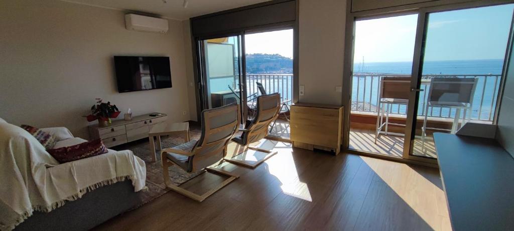 a living room with a couch and chairs and a balcony at LLOGUER30 Garbí Love, vistas espectaculares del mar in Sant Feliu de Guixols