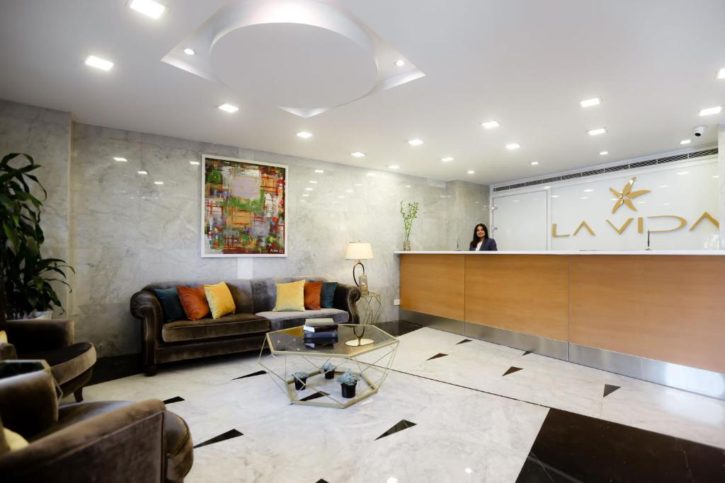 a woman standing at a counter in a lobby at La Vida Suite in Beirut